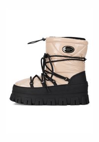 Beżowy lakierowany skórzany but z czarną gumową podeszwą, grubym wzorem bieżnika i regulowanymi sznurowadłami. Posiada owalną metkę z logo po boku.