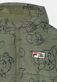 Giacca imbottita verde con cappuccio, caratterizzata da un design del cartone animato Tom e Jerry in nero. Include una toppa con il logo Fila sul petto.