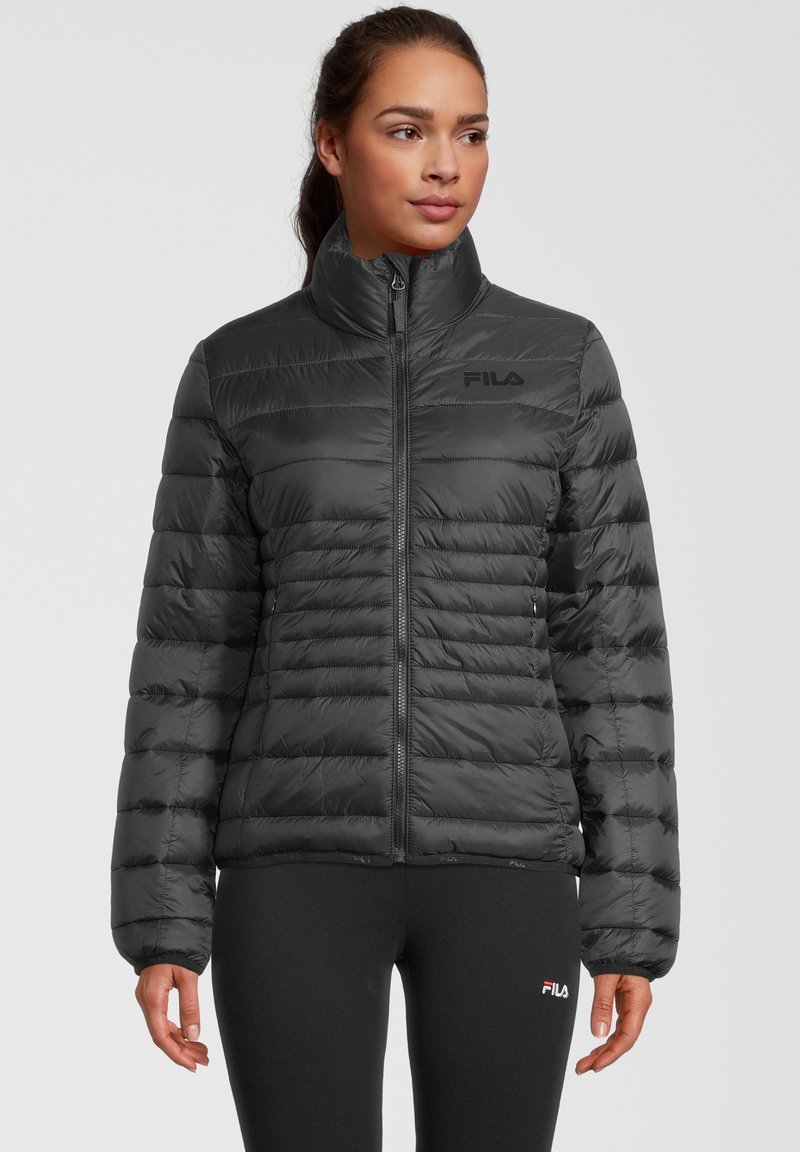 Giubbotto puffa nero con colletto alto e chiusura a zip, caratterizzato da un design trapuntato e un discreto logo sul petto. Texture morbida.