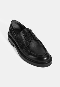 Schwarzer Lederschuh mit strukturiertem Finish, runder Zehenpartie und dreilöchrigem Schnürverschluss. Dicke Gummisohle mit rippigem Design.