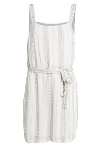 Ärmlös jumpsuit i vitt tyg med vertikala ränder och blommiga detaljer. Har ett knytbälte i midjan och en avslappnad passform.