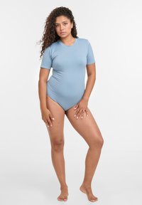 Svetlomodrý body s krátkym rukávom vyrobené z hladkej, elastickej látky. Má okrúhly výstrih a priliehavý strih, s minimalistickým dizajnom.