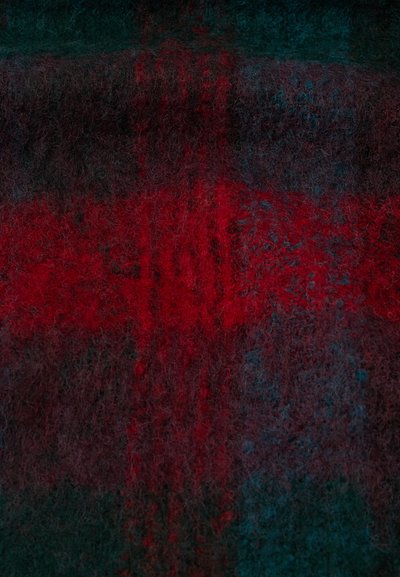 Tejido de lana con un patrón de cuadros en tonos rojos oscuros y verdes, con una textura suave y peluda y diferentes matices que crean profundidad.