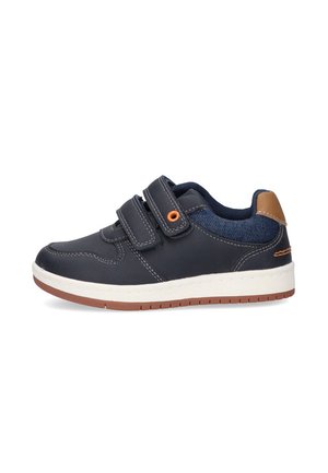 Zapatilla de color azul marino con dos tiras de Velcro, suela de goma blanca, acentos naranjas y forro de mezclilla. Punta redondeada y detalles cosidos.
