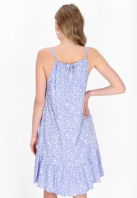 Rochie florală bleu deschis, cu spate plisat, bretele ajustabile și margine volanată. Realizată dintr-un material moale, cu un model delicat de flori.