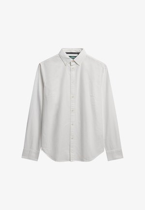 Chemise blanche en coton à manches longues avec un col à rabat, des boutons sur le devant, une poche poitrine simple et un ourlet courbé. Texture simple et lisse.