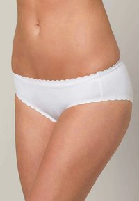 Woman wearing white scalloped-edge hipster underwear, shown from mid-torso to upper thighs against a plain background.