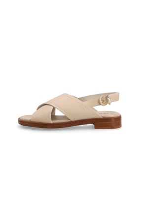 Sandalo in pelle beige con cinturini incrociati, cinturino regolabile con fibbia sul tallone e tacco basso in blocco di legno su sfondo bianco.