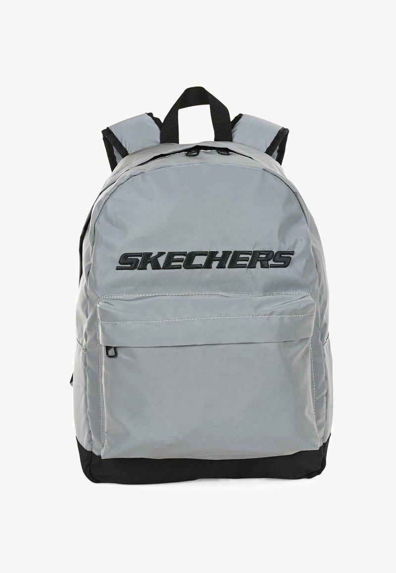 Mochila de tela gris con un gran bolsillo frontal, base negra y un destacado logotipo "SKECHERS" en negro. Correas de hombro acolchadas y asa superior.