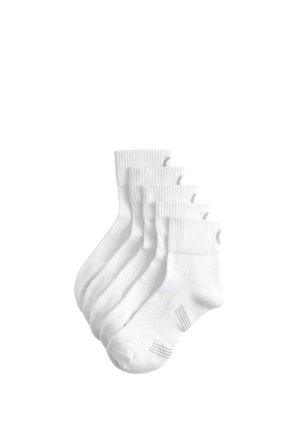 Cinque paia di calzini bianchi alla caviglia con polsini a coste e dettagli a righe grigie impilati su uno sfondo bianco.