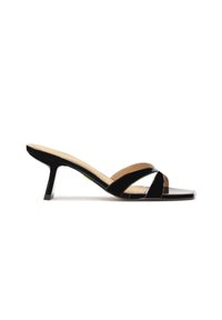 Zwarte gepatenteerde leren sandalen met hakken en een open teen, met gekruiste banden en een vierkante teenvorm, geplaatst op een korte stilettohak.
