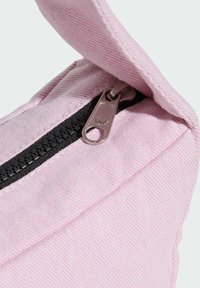 Sac en tissu rose avec une surface légèrement texturée, dotée d'une fermeture éclair noire et d'un tirette métallique avec un détail de marque.