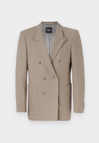 Beige double-breasted blazer with two large front pockets, sharp lapels, and silver-tone buttons. Features a solid texture and tailored fit.