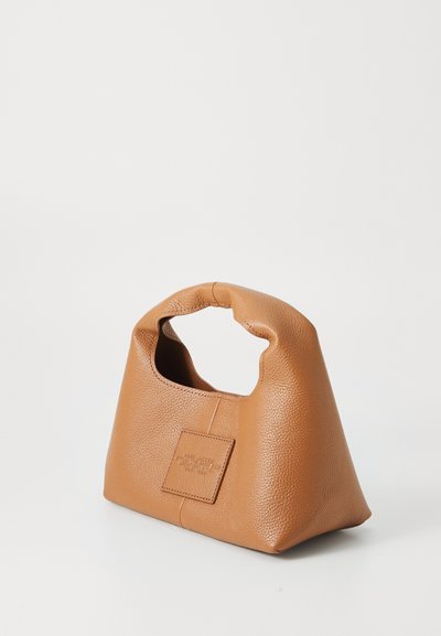Braune Lederhandtasche mit strukturierter Form, ausgestattet mit einem Ausschnittgriff und einem rechteckigen Patch an der Seite. Strukturierte Oberflächendetails.