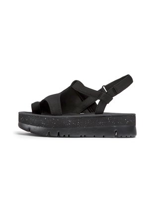 Black sandal with a cushioned sole, adjustable strap, and cross-over design. The sole features a textured, speckled pattern.