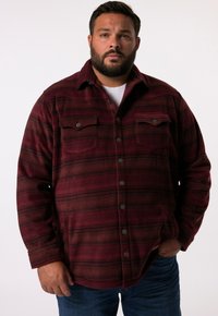 Bordeaux flannel skjorte med sorte striber, knap-til-design, to brystlommer og en blød, struktureret overflade. Stylet med blå jeans.