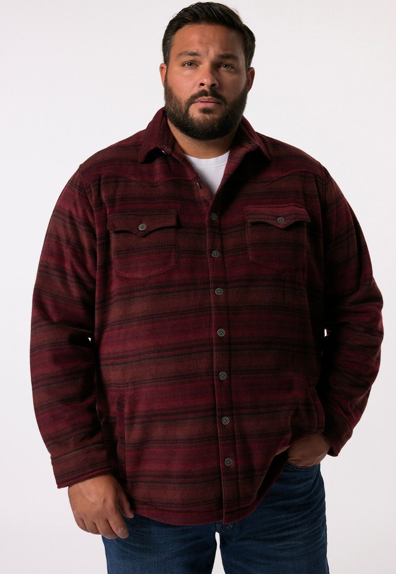 Mörkröd flanellskjorta med svarta ränder, knapplåsning, två bröstfickor och en mjuk, texturerad finish. Styler med blå jeans.