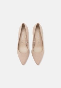 Talons hauts en daim beige avec un design à bout pointu, présentant une texture lisse et une semelle intérieure rembourrée. L'intérieur affiche un marquage de la marque.