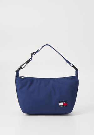 Granatowa torba na ramię z tkaniny z zamkiem błyskawicznym, z małą naszywką z logo Tommy Jeans. Regulowany pasek na ramię z metalowymi ozdobami.
