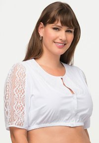 Blusa bianca corta con dettagli in pizzo sulle maniche corte e scollatura rotonda, con chiusura a bottone e orlo elasticizzato.
