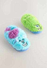 Blaue und grüne Plüschschuhe mit Cartoon-Monsterdesigns; Blau hat lila Akzente und ein lächelndes Gesicht, während Grün ein einzelnes Auge und ein Lächeln hat.