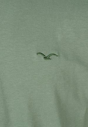 Green cotton t-shirt featuring a small, embroidered bird logo in dark green on the chest, soft texture, and a classic round neckline.