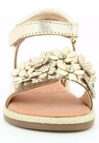 Sandale métallique dorée avec des embellissements floraux et des strass. Design ouvert à l'avant, bride ajustable et semelle texturée.