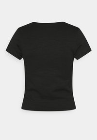 Svart kortärmad topp med ribbad textur, med rund halsringning och en figurnära silhuett. Baksidan är enkel och sömlös.