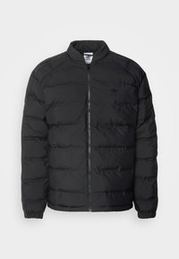 Schwarze Steppjacke mit Stehkragen, Reißverschluss vorne und gerippten Bündchen. Mit einem gesteppten Design und dezentem Logo auf der Brust.