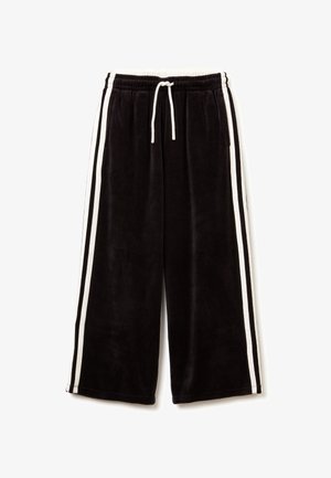 Zwarte velours trainingsbroek met witte zijstrepen, elastische tailleband en verstelbaar trekkoord. Kenmerkt een losse, cropped pasvorm.