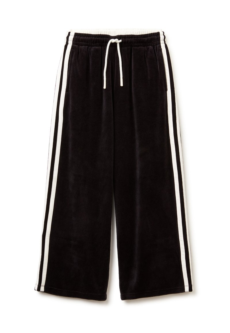 Pantalones de chándal de terciopelo negro con rayas laterales blancas, cinturilla elástica y cordón ajustable. Presentan un diseño holgado y cropped.