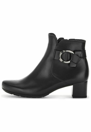 Bottine en cuir noir, avec un bout arrondi, fermeture éclair sur le côté et un accent décoratif en nœud avec un détail en matériel circulaire sur le côté.