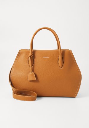 Tan leather handbag with textured finish, double handles, detachable shoulder strap, and contrasting white stitching. Features a clasp detail.