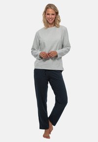Grijze longsleeve shirt met een ontspannen pasvorm, gecombineerd met marineblauwe pyjamabroek met stippen. Zacht materiaal, casual ontwerp.