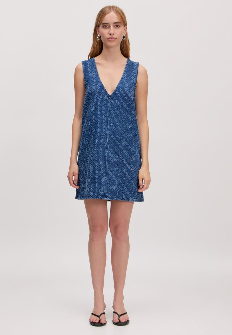 Blauwe mouwloze jurk met een diepe V-hals en een losse, ontspannen pasvorm. Heeft een subtiel patroon en een rechte zoom op knielengte.