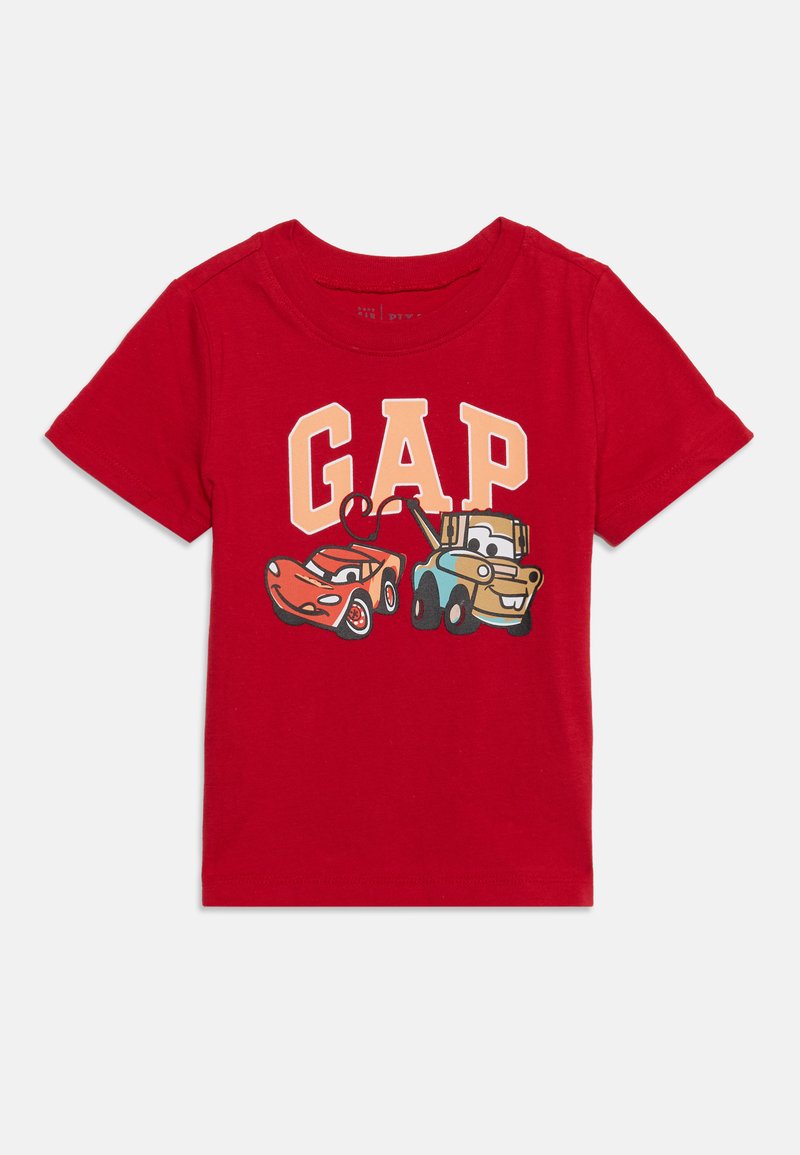 Κόκκινο παιδικό t-shirt με τη λέξη GAP και δύο κινούμενα αυτοκίνητα, ένα κόκκινο αγωνιστικό αυτοκίνητο και ένα μπλε γερανοφόρο, που χαμογελούν μπροστά.