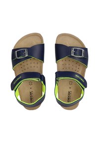 Sandales en cuir bleu marine avec des accents verts, dotées d'une boucle et d'une sangle ajustable, semelle intérieure texturée avec perforations pour la respirabilité.