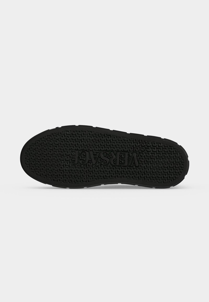 Schwarze Schuhsohle mit strukturiertem Muster und dem Wort "VERSACE" in der Mitte geprägt, dargestellt auf weißem Hintergrund.