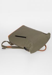 Olivgrüner wasserdichter Rucksack mit einer oberen Klappe aus braunem Leder, strukturierten Schultergurten und einer Reißverschlusstasche an der Seite. Leicht und funktional.