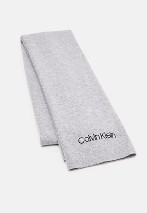 Écharpe pliée en tricot gris clair avec logo "Calvin Klein" noir brodé près d'une extrémité sur un fond blanc.