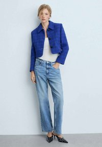 Modra tweed kratka jakna, črne gumbe, vCombinationWith z svetlo modrimi ravnimi kavbojkami in črnimi ostro koničastimi čevlji z očesnimi detajli.