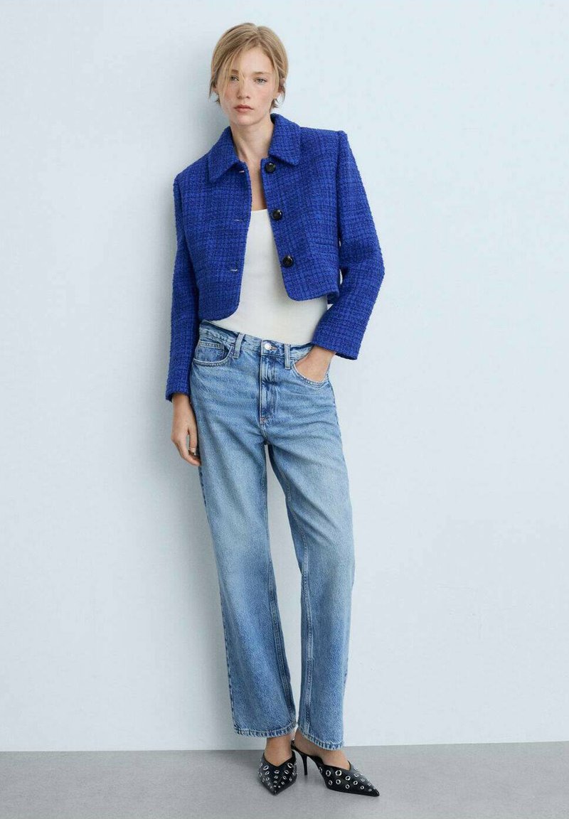 Modra tweed kratka jakna, črne gumbe, vCombinationWith z svetlo modrimi ravnimi kavbojkami in črnimi ostro koničastimi čevlji z očesnimi detajli.