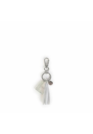 Il portachiavi presenta un gancio in metallo argentato, un charm L-shaped trasparente e glitterato, una nappina bianca e un piccolo accento metallico rotondo.