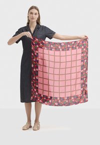 Écharpe à motifs avec une bordure florale, centre rose présentant un motif en grille. Fabriquée en tissu léger, aux couleurs vives et à la texture lisse.