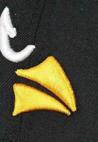 Embroidered patch featuring a yellow double triangle design on a black textured fabric background, with a white curved accent.