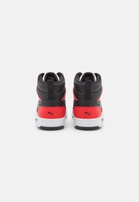 Czerwono-czarne sneakersy typu high-top z eleganckim designem, teksturowaną skórą, wyściełanym kołnierzem oraz białą gumową podeszwą z czarnymi akcentami.