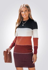 Gebreide jurk met horizontale strepen in zwart, wit, oranje en bordeauxrood, met geribbelde manchetten en decoratieve stikdetails.