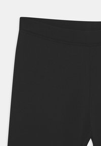 Zwarte, stretch leggings met een gladde textuur, voorzien van een hoge tailleband en vlakke naden voor comfort en duurzaamheid.