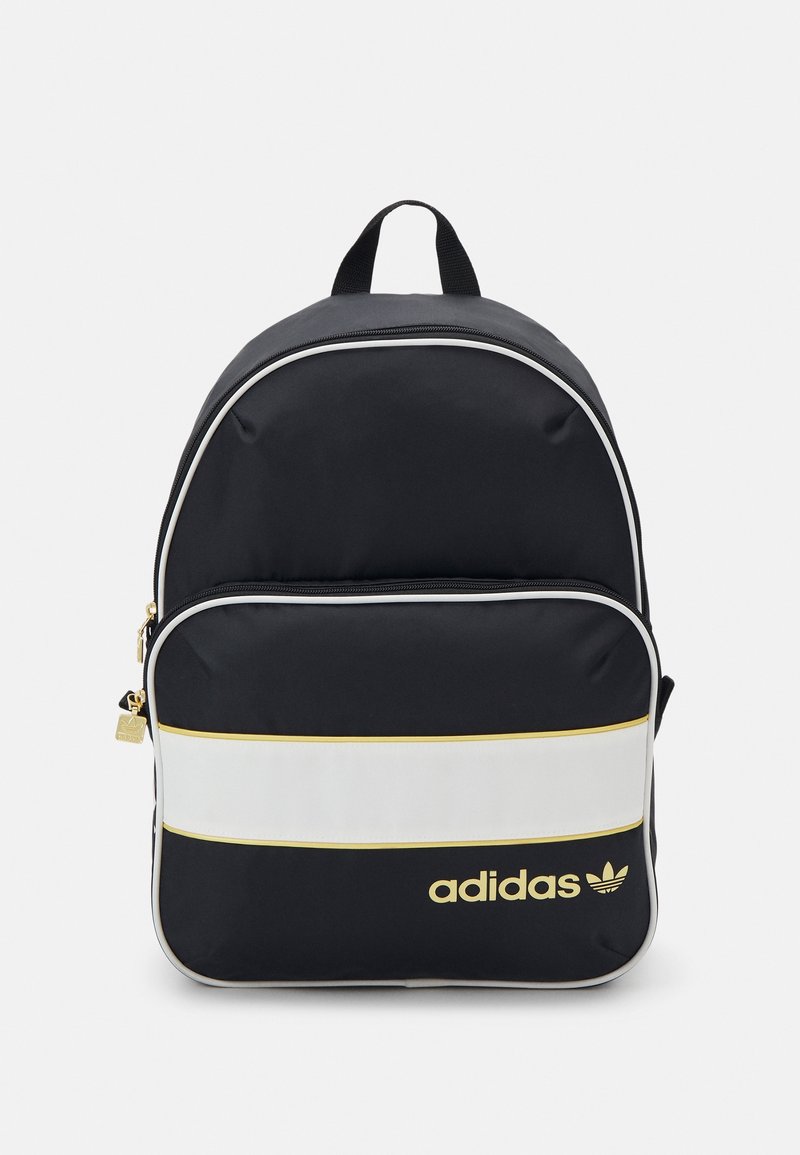 Black backpack featuring white and gold horizontal stripes, zippered main compartment, front pocket, and gold logo accent. Durable fabric.