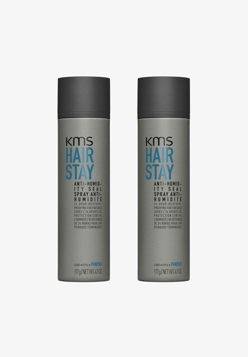Two gray aerosol spray cans labeled "KMS Hair Stay Anti-Humidity Seal." Each 117g, with a dark cap and blue text detailing product features.